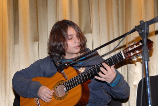 νεαρός παίζει κιθάρα σε συναυλία του Ελεύθερου Ωδείου