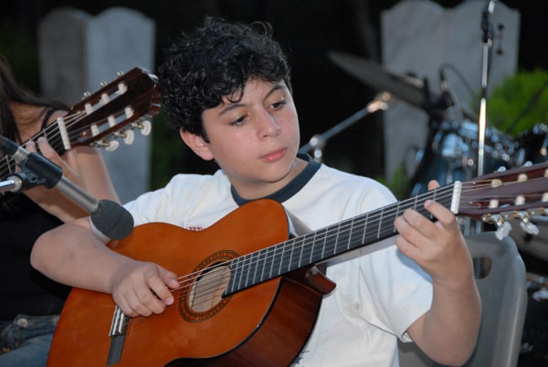 αγόρι παίζει κιθάρα σε συναυλία του Ελεύθερου Ωδείου